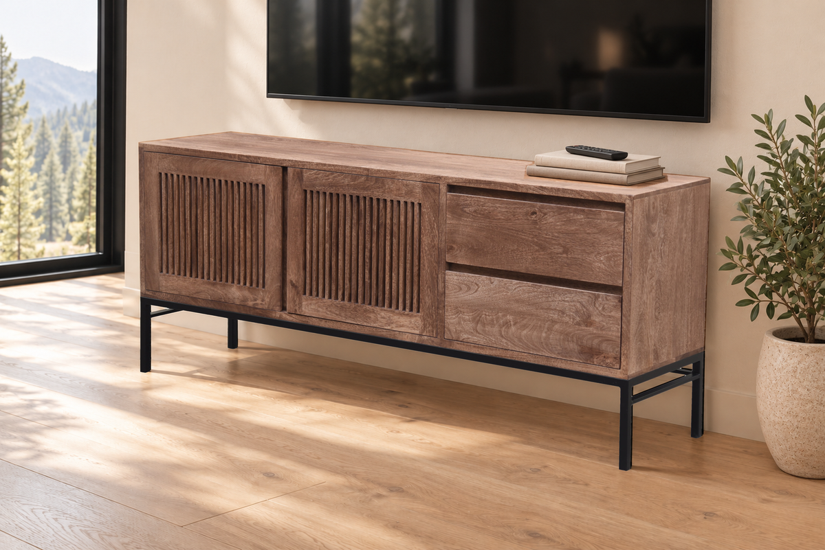 Marcell 72-inch hardwood media cabinet beneath a wall-mounted TV beside a potted plant in a sunlit living room